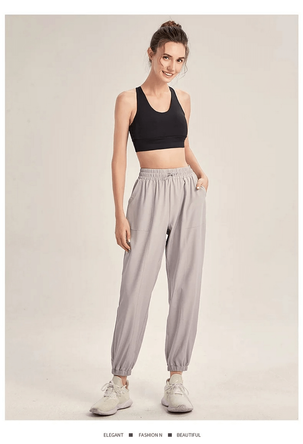 Woman wearing gray stylish drawstring joggers, perfect for yoga, gym, and dance. Flexible and durable athletic pants for women.
